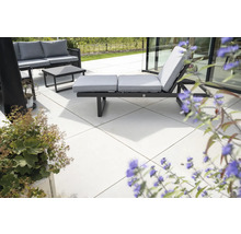 Terrasse mit Gartenmöbeln, bestehend aus Sofa, Tisch und Sonnenliege mit Auflagen.