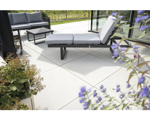 Terrasse mit Gartenmöbeln, bestehend aus Sofa, Tisch und Sonnenliege mit Auflagen.