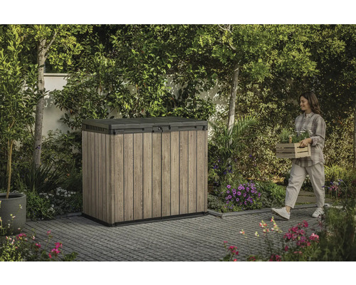 Gartenschrank im Außenbereich mit Frau, die Pflanzen trägt