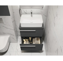 Badezimmer mit Waschbecken, Unterschrank und geöffneter Schublade mit Pflegeprodukten