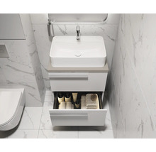Modernes Badezimmer mit weißem Waschtischunterschrank und offenem Schubfach für Badutensilien.