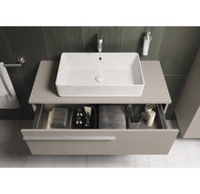 Modernes Badezimmer mit rechteckigem Aufsatzwaschbecken, Unterschrank und geöffneter Schublade mit Badutensilien.