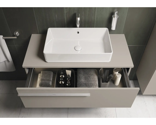 Modernes Badezimmer mit rechteckigem Aufsatzwaschbecken, Unterschrank und geöffneter Schublade mit Badutensilien.
