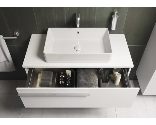 Modernes Badezimmer mit Waschbecken und offenem Schubladensystem zur Aufbewahrung von Badutensilien.