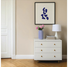 Szene mit weißer Kommode, Lampe, Blumen in einer Vase und einem gerahmten Bild an der Wand