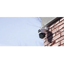 Außen montierte Überwachungskamera an einer Backsteinmauer