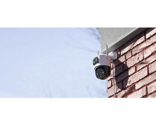 Außen montierte Überwachungskamera an einer Backsteinmauer