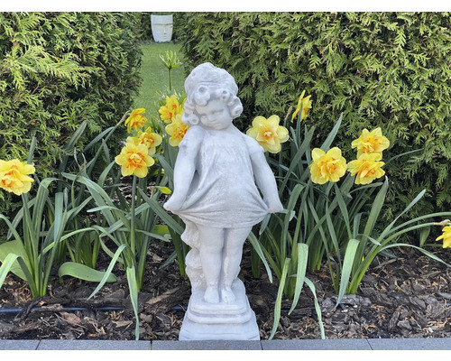 Gartenansicht mit Mädchenfigur aus Stein und gelben Narzissen