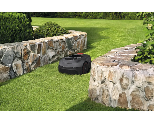 Rasenroboter auf Rasenfläche zwischen zwei Steinmauern