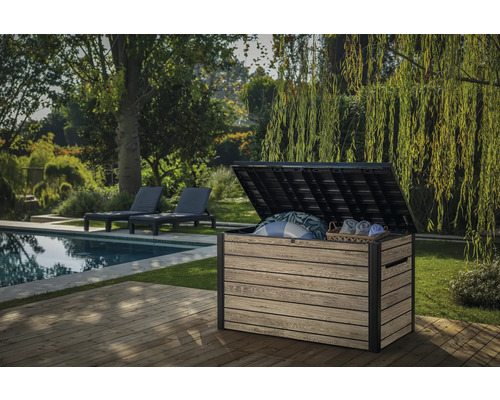 Garten Szene mit einer geöffneten Aufbewahrungsbox aus Kunststoff auf einer Terrasse mit Pool und Liegen