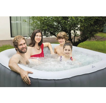 Familie entspannt in einem aufblasbaren Whirlpool im Garten.