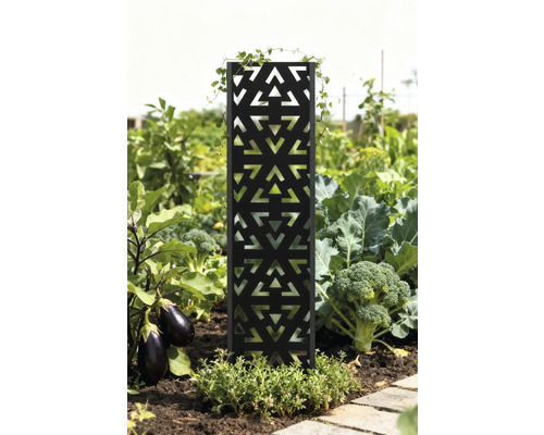Dekorative Gartenstele mit geometrischem Muster in einem Gemüsebeet.