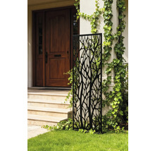 Dekorative Gartenwand mit Baummuster vor einem Haus.