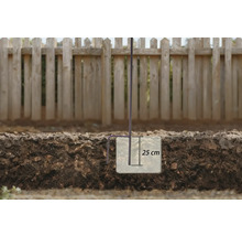 Illustration eines Erdankers mit einer Tiefe von 25 cm im Boden vor einem Holzzaun.