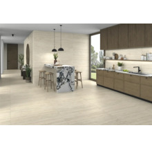 Heller Raum mit Küchenzeile, Bartisch mit Barhockern und Fliesenboden.