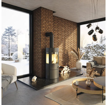 Wohnzimmer mit Kaminofen, Ziegelwand und Fensterblick auf eine verschneite Landschaft