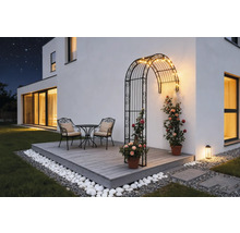 Terrasse mit Rosenbogen, Tischgruppe und Dekoration im Garten