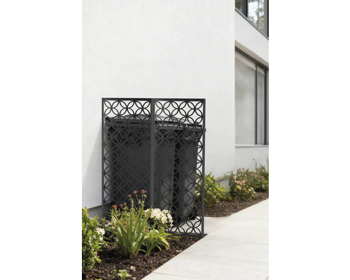 Mülltonnenbox mit dekorativem Gitter vor einer weißen Hauswand