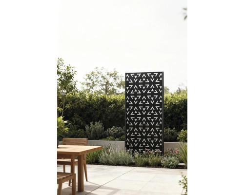 Dekorativer Sichtschutz aus Metall mit Dreiecksmuster im Garten neben einer Sitzecke
