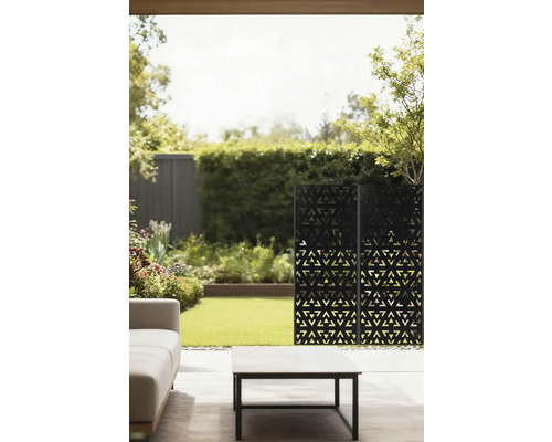 Außenbereich mit Sichtschutzwand, Sofa und Tisch auf einer Terrasse mit Rasenfläche