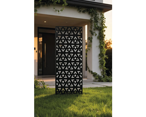 Dekorativer Gartenzaun aus Metall mit dreieckigem Muster vor einem Haus