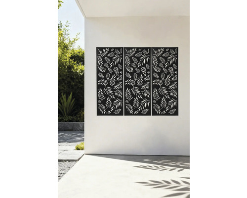 Drei dekorative Sichtschutzelemente mit Blattmuster an einer Hauswand