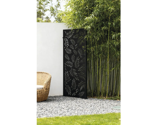 Dekorative Gartenszene mit einem Sichtschutzelement mit Blättermuster, Bambuspflanzen und einem Korbsessel