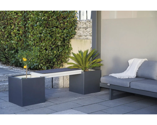 Gartenmöbelanordnung mit Pflanzgefäßen, die als Bank dienen, und einem Sofa auf einer Terrasse.