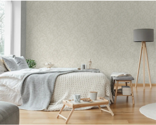 Helles Schlafzimmer mit gemusterter Tapete, Bett, Lampe und Beistelltisch
