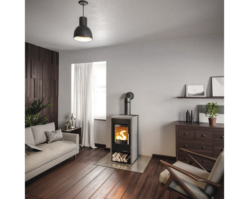 Wohnzimmer mit Kaminofen, Sofa, Sessel, Kommode und Dekoration für ein gemütliches Ambiente