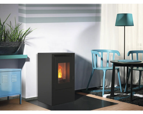 Wohnzimmer mit Pelletofen, Tisch und Stühlen.