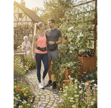 Paar mit Hüfttaschen steht in einem Garten mit Hochbeet.