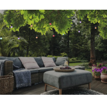 Gartenlounge mit Outdoor-Sitzgruppe und Lichterkette unter Bäumen