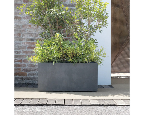 Rechteckiger Pflanzkasten aus Fiberglas mit Bepflanzung vor einer Ziegelwand