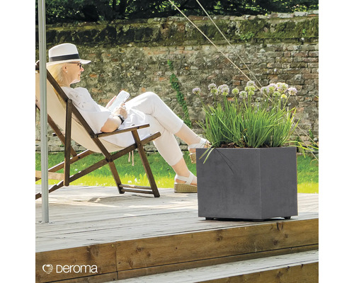 Szene mit Frau in einem Liegestuhl neben einem grauen Pflanzgefäß mit Pflanzen auf einer Holzterrasse