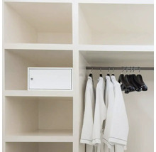 Einbauschrank mit einer darin integrierten Medikamentenbox, Kleidung und Kleiderbügel.