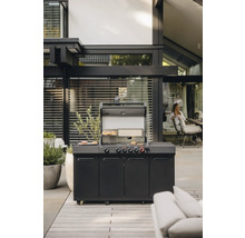 Außenszene mit einem schwarzen Gasgrill mit geöffnetem Deckel, unter dem Grillgut liegt.