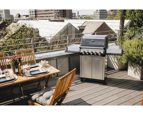 Gasgrill mit Tisch und Stühlen auf einer Dachterrasse