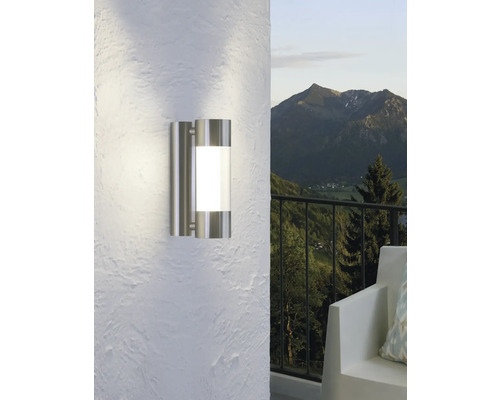 Moderne Wandleuchte aus Edelstahl für den Außenbereich, montiert an einer weißen Wand.