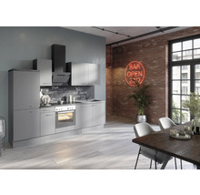 Moderne Küche mit grauen Schränken, Backofen und Dunstabzugshaube vor einer Backsteinwand mit Leuchtreklame