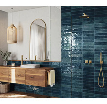 Modernes Badezimmer mit blauen Fliesen, Holzwaschtisch und goldenen Armaturen
