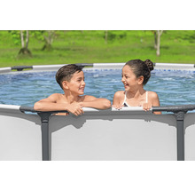 Zwei Kinder stehen in einem Stahlrahmenpool im Garten.