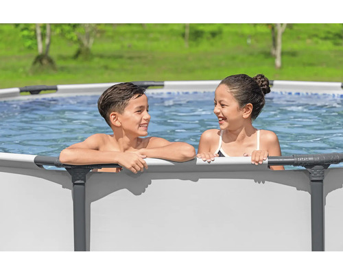 Zwei Kinder stehen in einem Stahlrahmenpool im Garten.