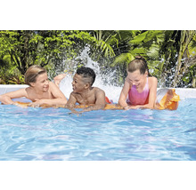 Drei Kinder spielen im Swimmingpool mit Wasserspritzern