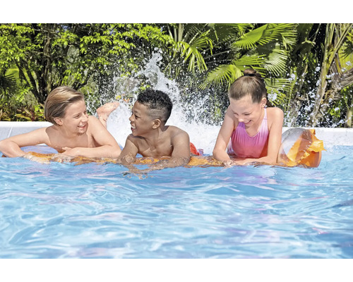 Drei Kinder spielen im Swimmingpool mit Wasserspritzern