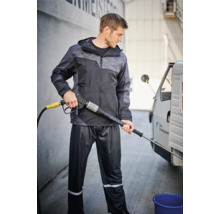 Mann mit Hochdruckreiniger in Regenbekleidung