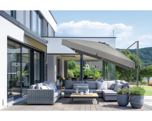 Terrasse mit Lounge-Möbeln, Sonnenschirm und Pflanzenkübeln vor modernem Haus