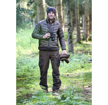 Mann mit Fernglas, Steppjacke, Mütze und Hose im Wald