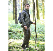 Mann mit Rucksack, Stecken, Steppjacke und Cargohose im Wald