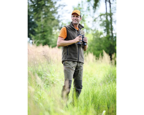 Mann mit Fernglas, Weste und Hose im Freien